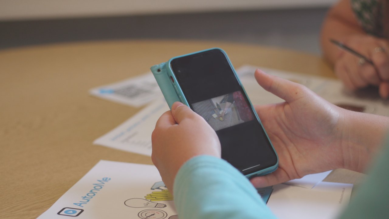 Learner using AutonoMe video to cook on phone.